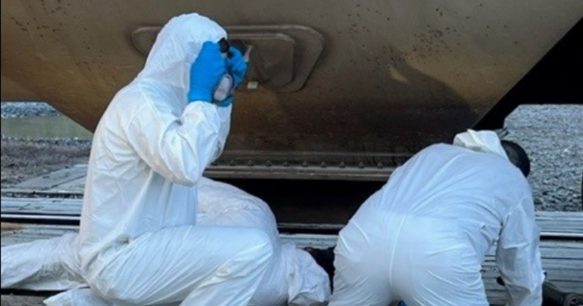 Two investigators work a scene on Monday, after workers at a Tyson factory in Arkansas discovered a decomposing body in a train that was delivering corn to the facility.